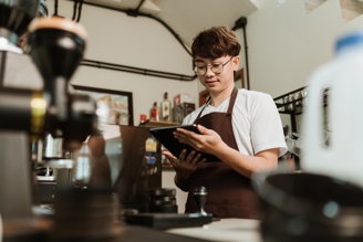 A young man working in a cafe.